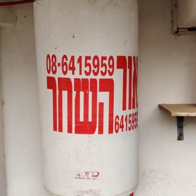 דוד שמש עם כיתוב אדום על קיר לבן