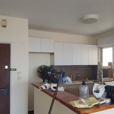 סולם עץ עם כתמי צבע ליד חלון במטבח