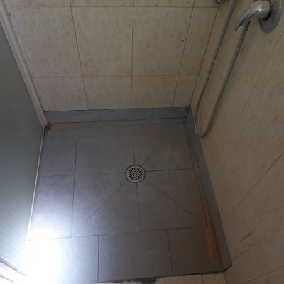 מקלחת עם רצפת אריחים וניקוז במרכז