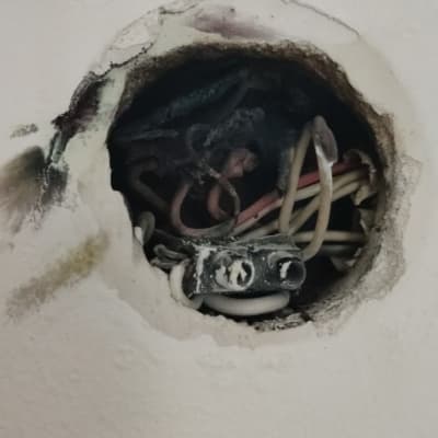 חוטי חשמל חשופים בקיר עם חיבורי מתכת