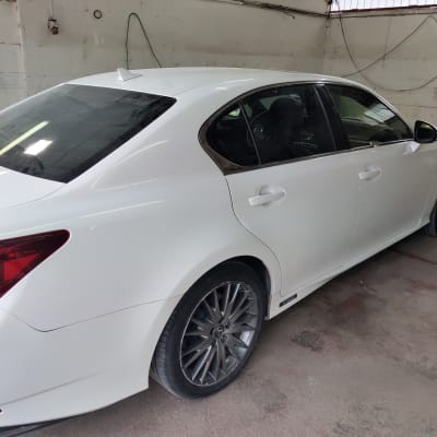 מכונית לבנה בחדר עבודה עם ציוד תיקון