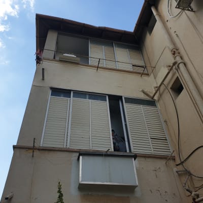 אדם עובד על איטום חלון בבניין