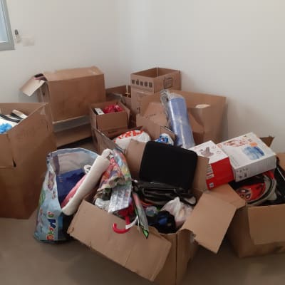 קופסאות קרטון מלאות חפצים שונים בחדר ריק