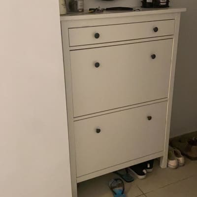 נעליים מתחת לארון לבן עם מראה עגולה