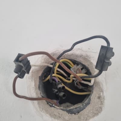 חוטי חשמל צבעוניים בקופסת חיבורים בקיר