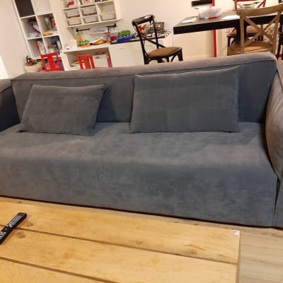 ספה אפורה עם כריות על שולחן עץ