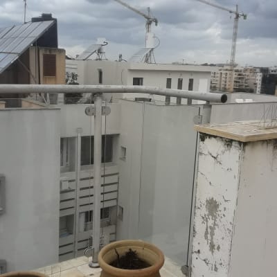 מעקה זכוכית במרפסת עם נוף עירוני