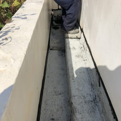 אדם יושב ליד קיר עם איטום שחור על הרצפה