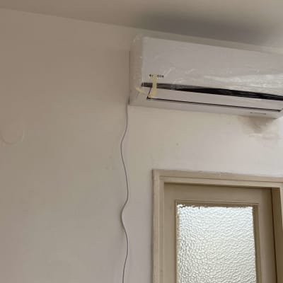 מזגן מותקן על קיר עם כבל חשמל תלוי