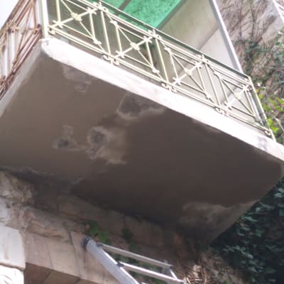 מרפסת עם תיקוני טיח וסולם מתכת