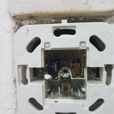 שקע חשמלי פתוח עם חוטים חשופים ונזק