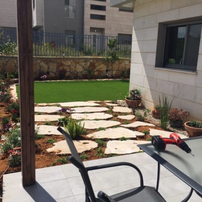 שביל אבנים בגינה עם צמחים ופרחים מסביב