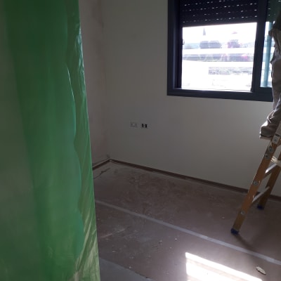 חדר עם סולם, יריעת פלסטיק ירוקה, קיר צבוע חלקית