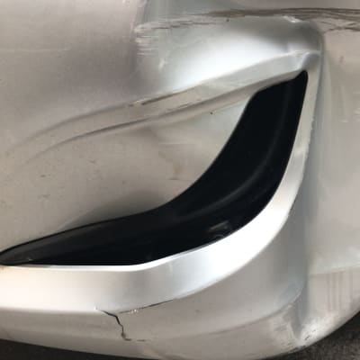 פגוש רכב כסוף עם שריטות וסדקים