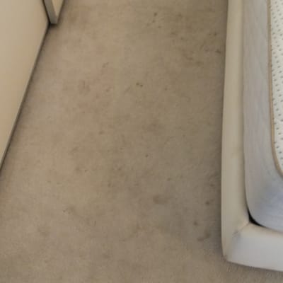 שטיח עם כתמים ליד מיטה