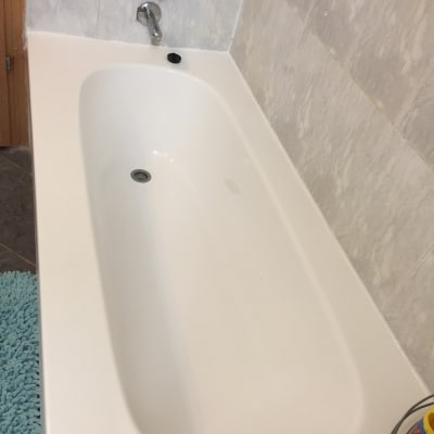 אמבטיה לבנה עם חיפוי קיר שיש וברז כרום