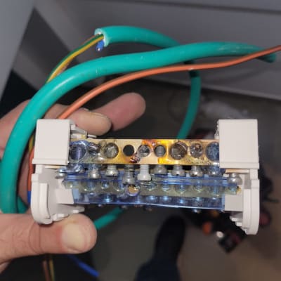 חוטי חשמל צבעוניים ומחבר חשמלי ביד חשמלאי