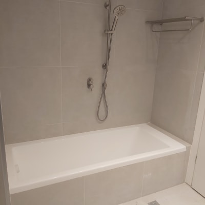 אמבטיה חדשה עם אריחים אפורים ומקלחת יד