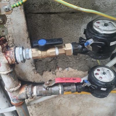 שני מדי מים עם ברזים וצינורות מחוברים לקיר