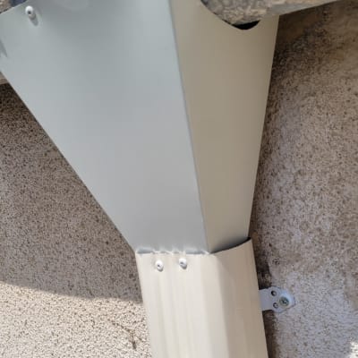 מרזב מתכת מחובר לקיר בטון עם ברגים