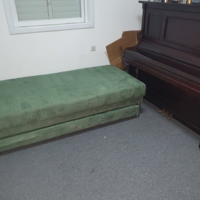 מזרן ירוק וקרטון ליד פסנתר בחדר