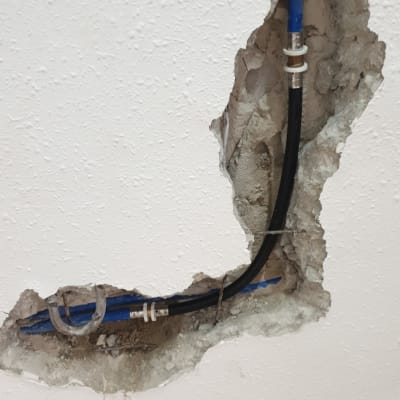 צינורות מים חשופים בקיר שבור