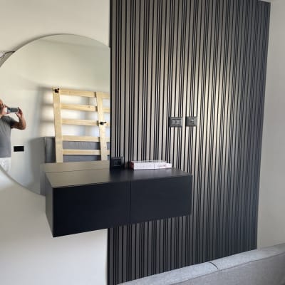 מראה עגולה, קיר עם פסים, ארון שחור תלוי