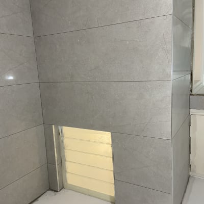 אריחי קרמיקה מותקנים על קיר במהלך שיפוץ