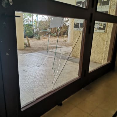 זכוכית שבורה בדלת עץ עם סדקים גדולים