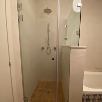 מקלחת עם דלת זכוכית וראש מקלחת עגול