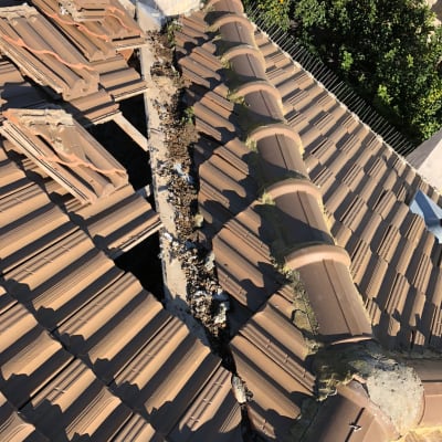 רעפים שבורים על גג עם לכלוך ופסולת