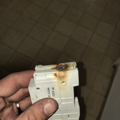 חלק חשמלי עם סימני שריפה ביד של אדם