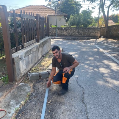 אדם מחזיק מסגרת מתכת על המדרכה