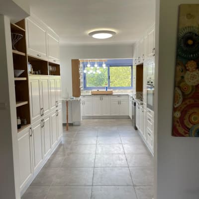 מטבח מודרני עם ארונות לבנים ותאורה עגולה