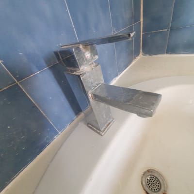 ברז מתכתי עם כתמי אבנית בכיור