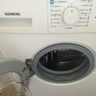 מכונת כביסה פתוחה עם כפתור בקרה ותוכניות כביסה