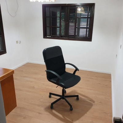 רצפת פרקט עץ בהירה בחדר ריק עם כיסא משרדי