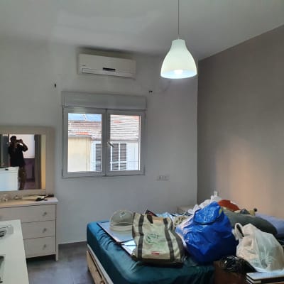 קיר צבוע בצבע אפור בהיר עם מנורה תלויה