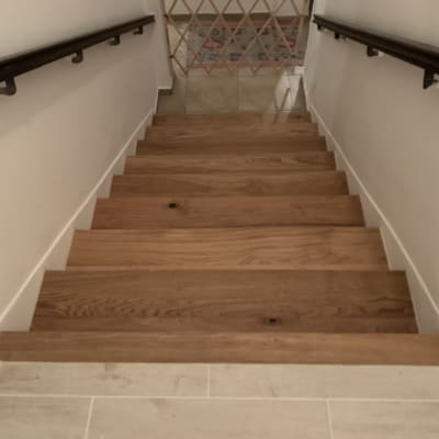 מדרגות עץ עם מעקה מתכת בצדדים