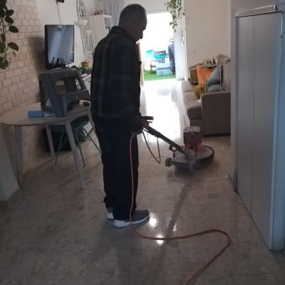 אדם מנקה רצפה עם מכונת פוליש חשמלית