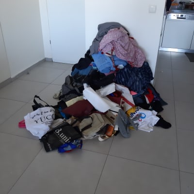 ערימת בגדים ותיקים על רצפת חדר