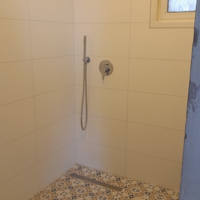 מקלחת עם אריחים מעוצבים וראש טוש חדש