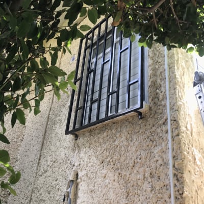 חלון עם סורגים שחורים על קיר חיצוני