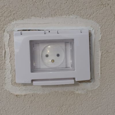 שקע חשמל עם כיסוי פלסטיק שקוף על קיר