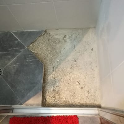 רצפה עם אריחים שבורים וחול חשוף בשיפוץ