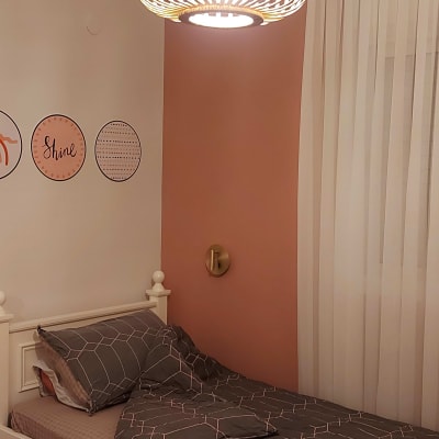 מנורת תקרה מעוצבת תלויה מעל מיטה בחדר שינה