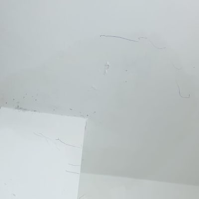 קיר לבן עם סימני צבע ותיקונים