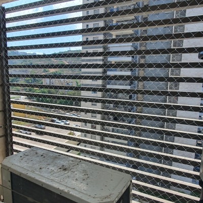 רשת מתכת מותקנת על חלון למניעת כניסת יונים