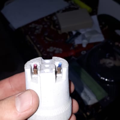 שקע חשמלי עם חוטים חשופים ביד אדם