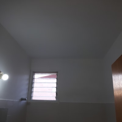 קיר ותקרה צבועים בלבן עם חלון קטן